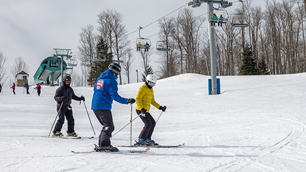 A Holiday Valley Snowsports instructor works with two clients during an intermediate ski lesson.